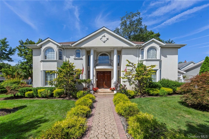 Neoclassical / greek revival house with stucco siding and a front lawn