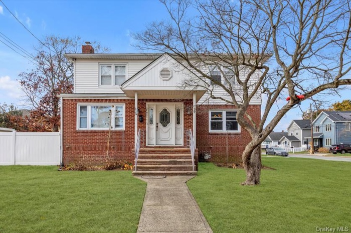 Bungalow-style home with brick siding and a chimney
