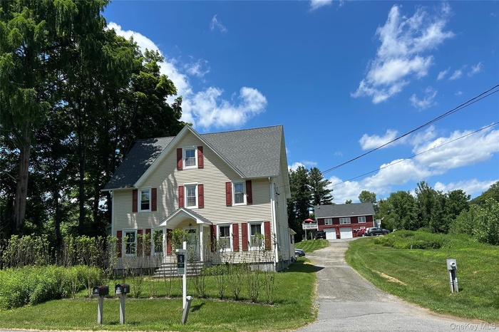 View of front of home featuring a front lawn and roof with shingles