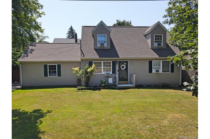 Cape cod house featuring a front lawn and roof with shingles