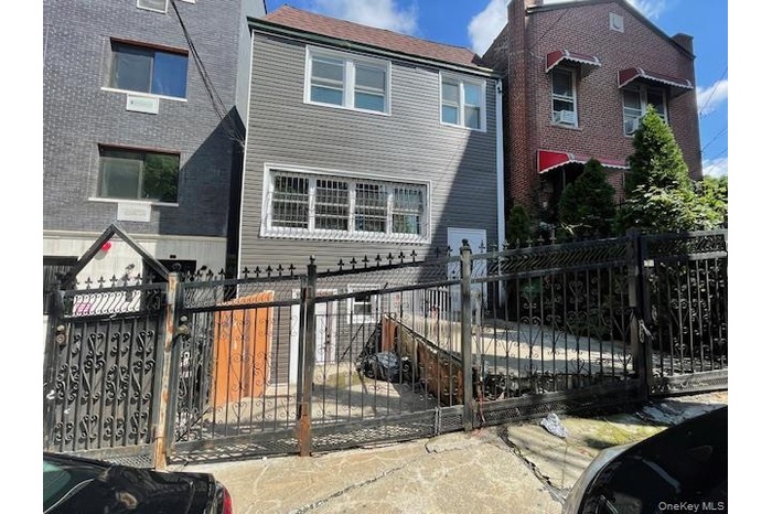 View of front of property with a fenced front yard and a gate