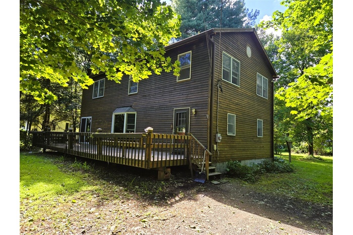 featuring a wooden deck and a lawn