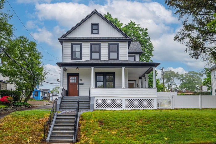 View of front of home featuring a porch, roof with shingles, fence, a front yard, and board and batten siding