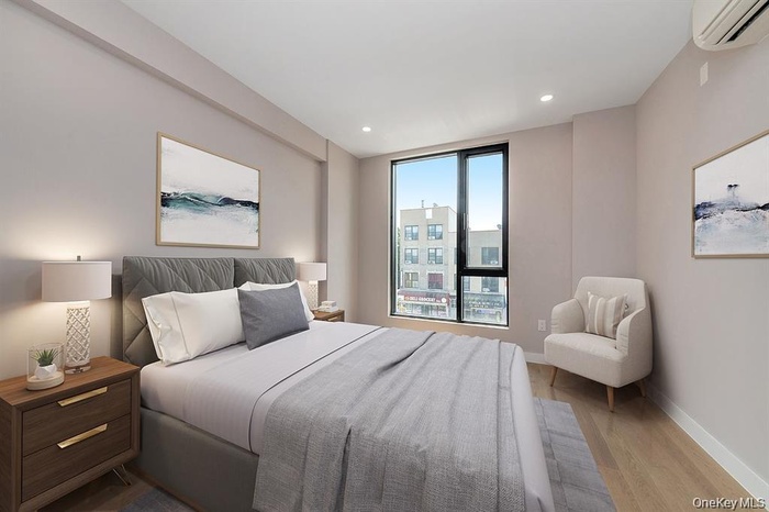 Bedroom with an AC wall unit, wood finished floors, and recessed lighting