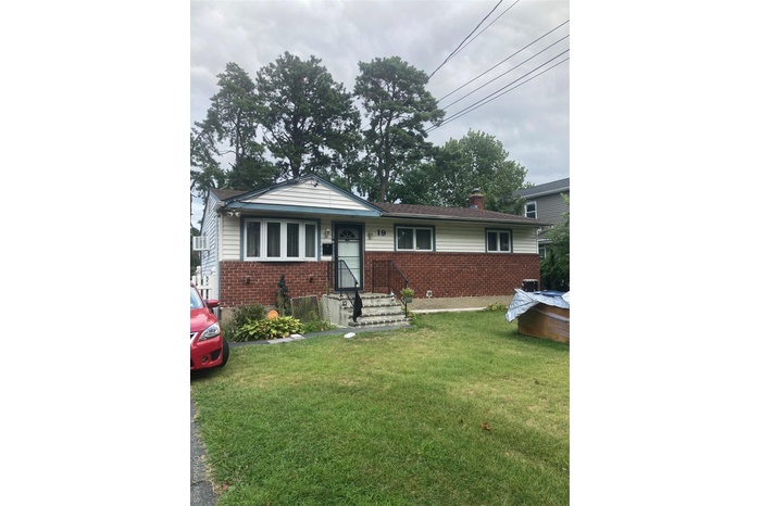 Single story home featuring brick siding, a front lawn, and a chimney