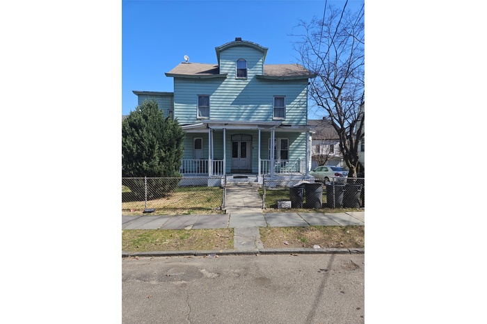 View of front of home with fence and covered porch