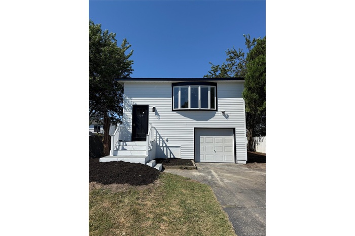 Bi-level home with an attached garage and asphalt driveway