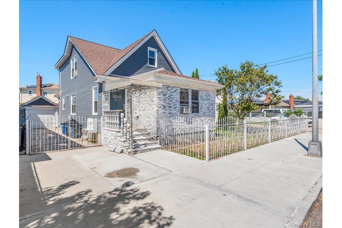 View of front of house with a fenced front yard, driveway, a garage, a gate, and roof with shingles