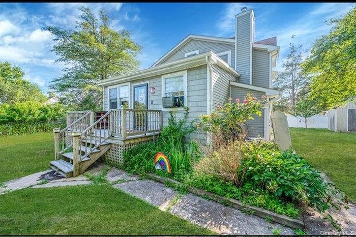 View of front of home featuring a chimney and a deck