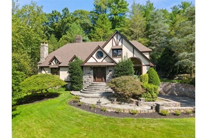 Blending timeless Tudor architecture with Scandinavian elegance, this luxurious residence offers a modern simplicity and country club living.