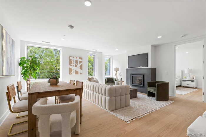 Living area featuring plenty of natural light, a glass covered fireplace, light wood finished floors, and recessed lighting