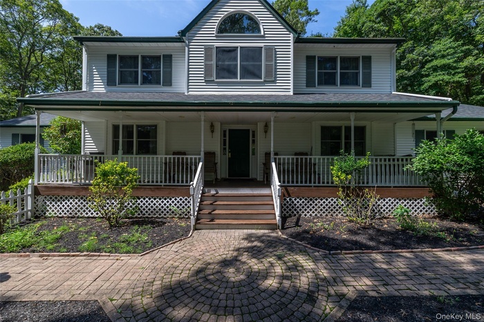 View of front facade with a porch and a shingled roof