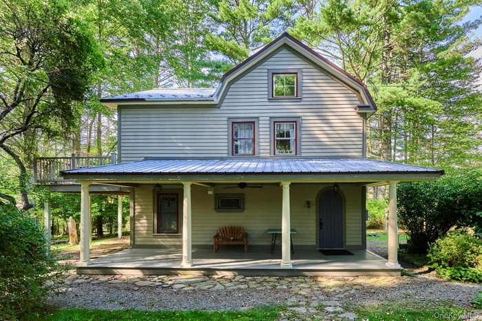 View of front of property featuring a metal roof and a large porch