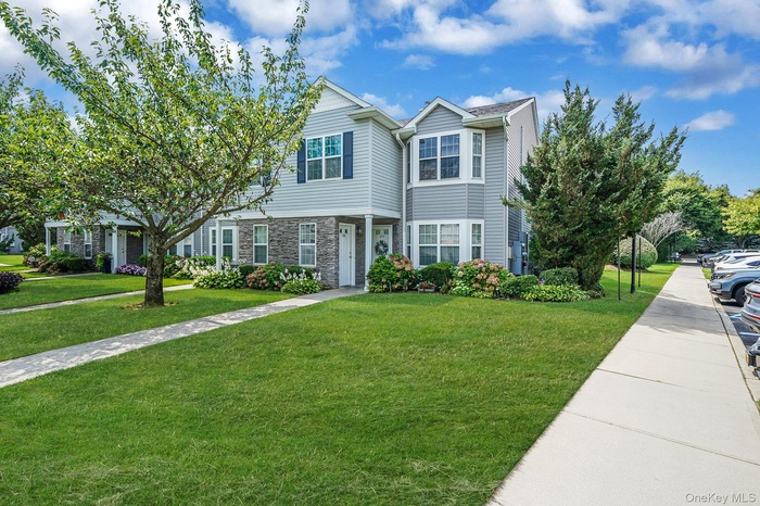 View of front of home with a front yard and stone siding