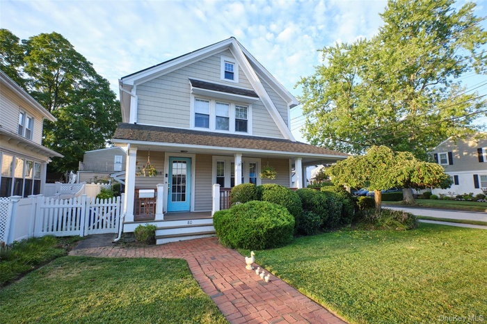 View of front facade with a porch and a shingled roof