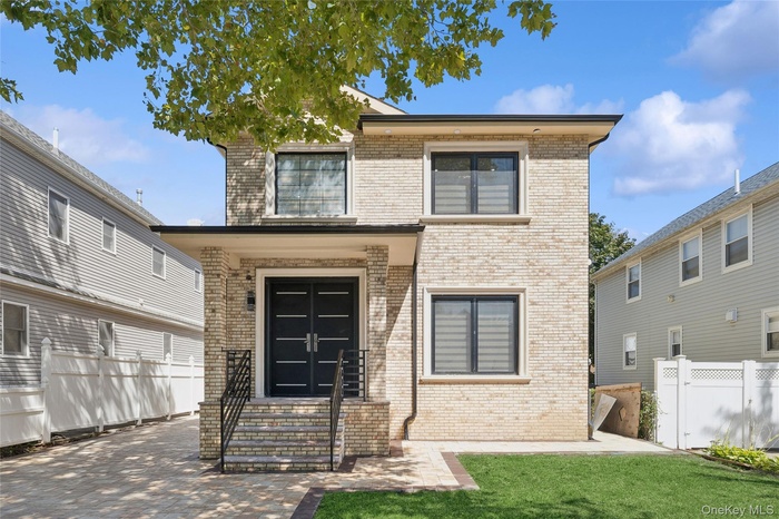 View of front of property featuring brick siding and a patio area