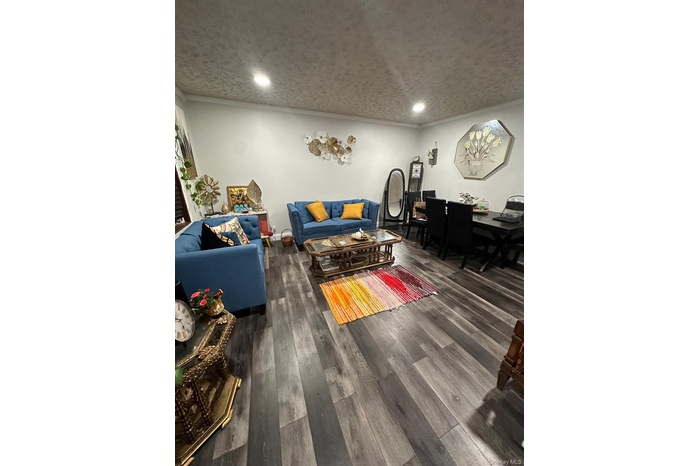 Living room featuring a textured ceiling, dark wood-style floors, and recessed lighting