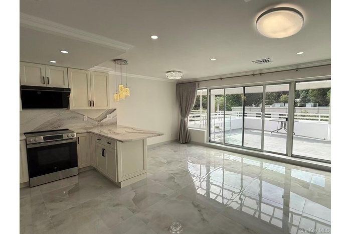Kitchen featuring electric stove, ornamental molding, light stone countertops, light marble finish flooring, and a peninsula