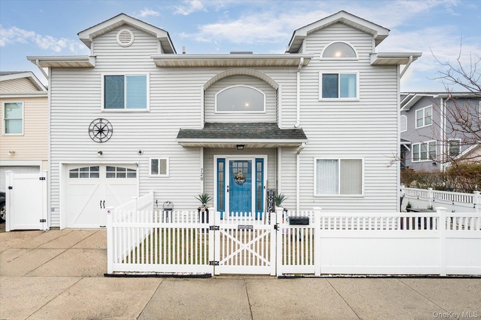 View of front of house with a gate, an attached garage, concrete driveway, and a fenced front yard