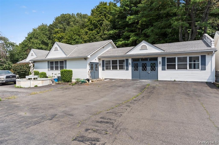 Single story home with a shingled roof, asphalt driveway, and french doors