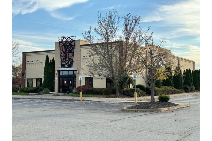 View of property featuring uncovered parking