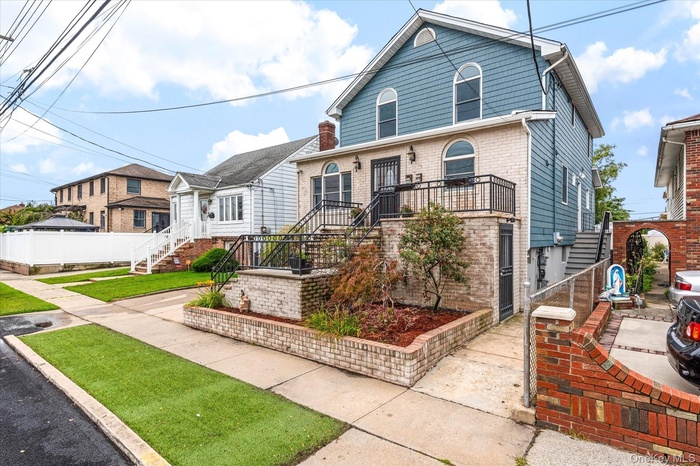 View of front of house with brick siding and stairway