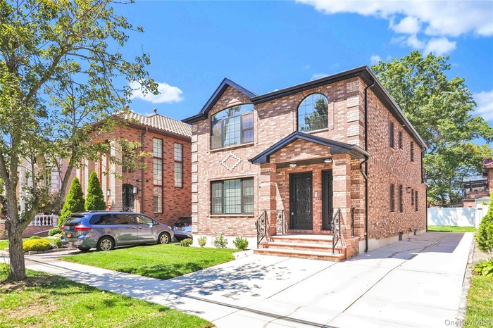 View of front of house with brick siding and a front lawn