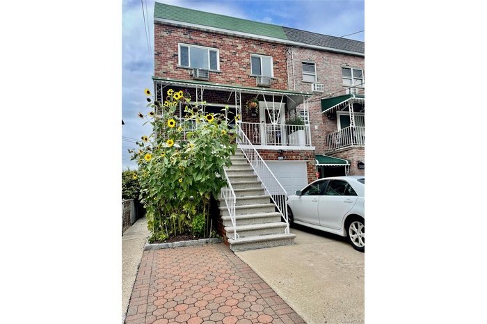 View of front of home with stairway, brick siding, concrete driveway, and an attached garage
