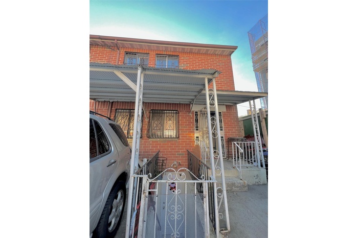 View of front of home featuring brick siding, a porch, a fenced front yard, and a gate