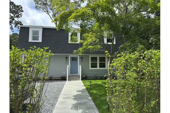 View of front of home featuring a shingled roof and a front lawn