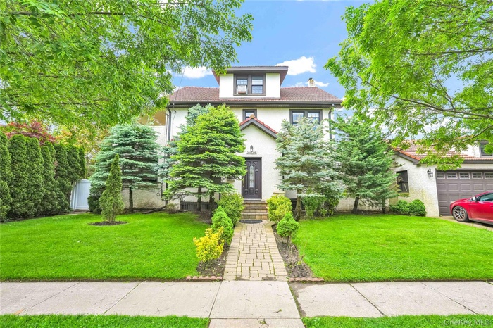 View of front facade featuring stucco siding and a front lawn