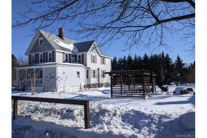 View of snowy exterior with a chimney