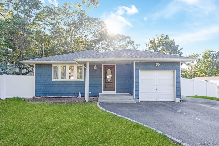 Single story home with an attached garage, a shingled roof, and asphalt driveway