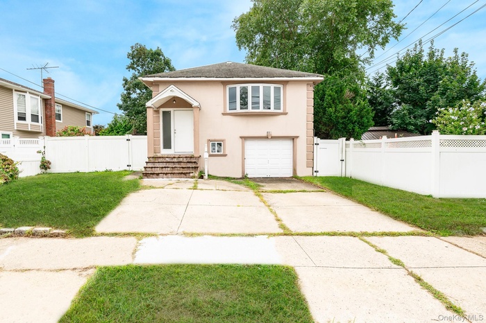 View of front facade featuring a gate, driveway, stucco siding, a shingled roof, and an attached garage