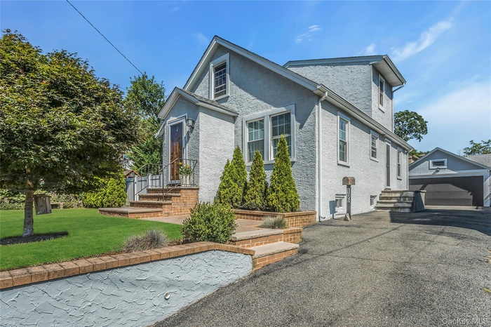 View of home's exterior featuring an outbuilding, stucco siding, and a lawn