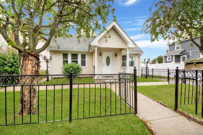 Bungalow with a fenced front yard, roof with shingles, and a gate