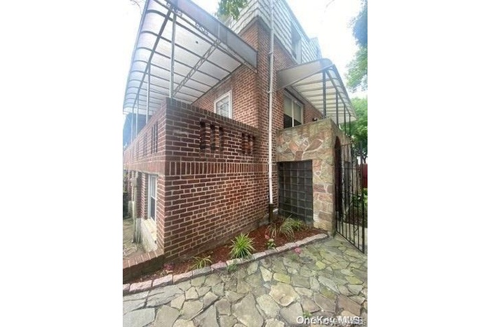 View of property exterior featuring brick siding and a patio