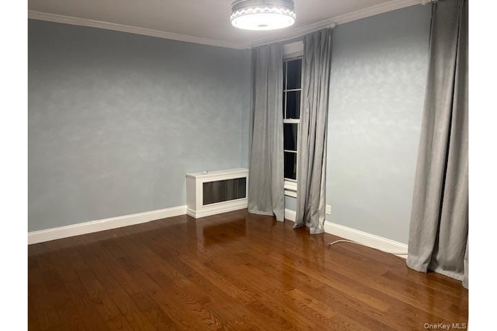 Bedroom featuring ornamental molding and dark wood-style floors