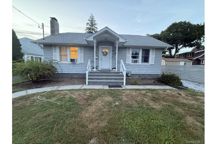 Bungalow featuring a shingled roof and a chimney