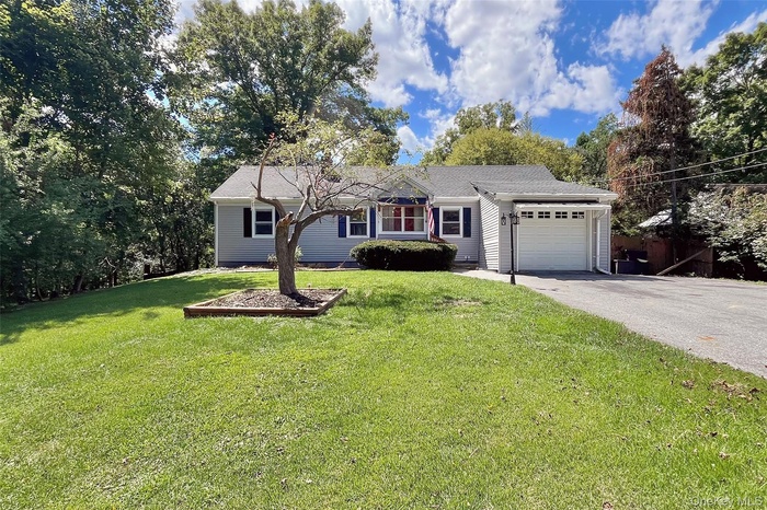 Ranch-style home with a garage, driveway, and a front yard