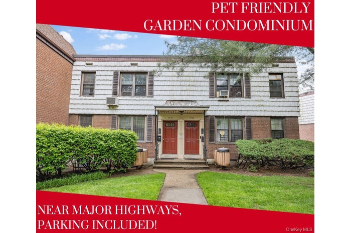 View of front of property with brick siding and a wall mounted air conditioner