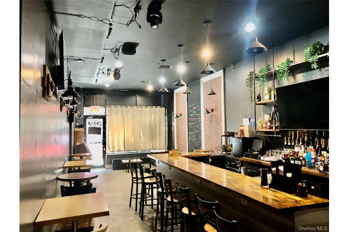 Community bar area featuring wood counters, open shelves, and dark cabinets