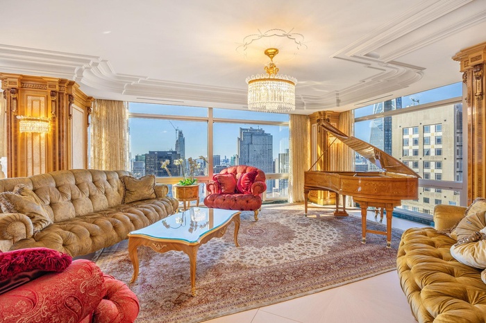 Tiled living room with a healthy amount of sunlight, a view of city, floor to ceiling windows, and a chandelier