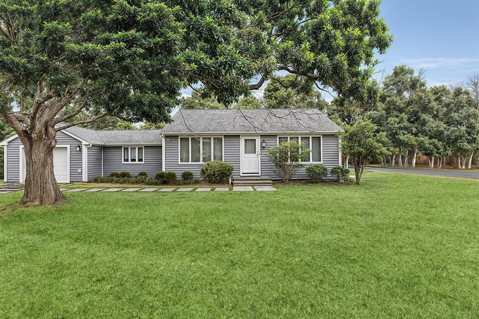 Ranch-style house with a garage and a front lawn