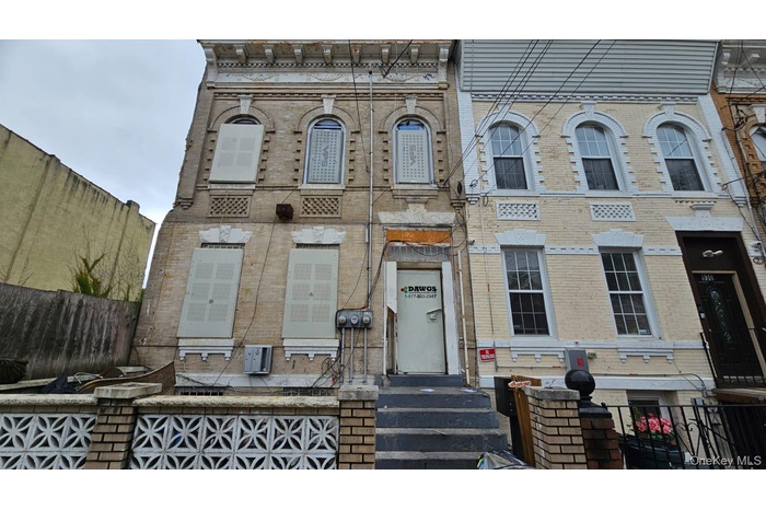 Italianate-style house featuring a fenced front yard and brick siding