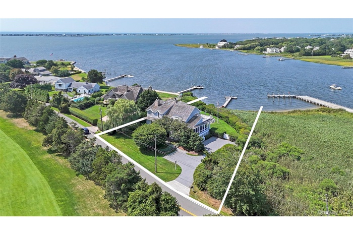 Aerial view of residential area featuring a nearby body of water and property boundaries highlighted