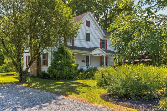 Colonial house with covered porch, a front lawn.