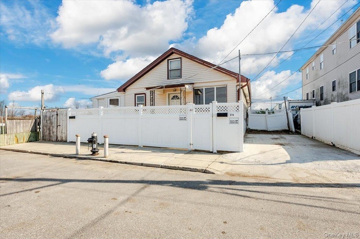 Bungalow-style house featuring a fenced front yard and a gate