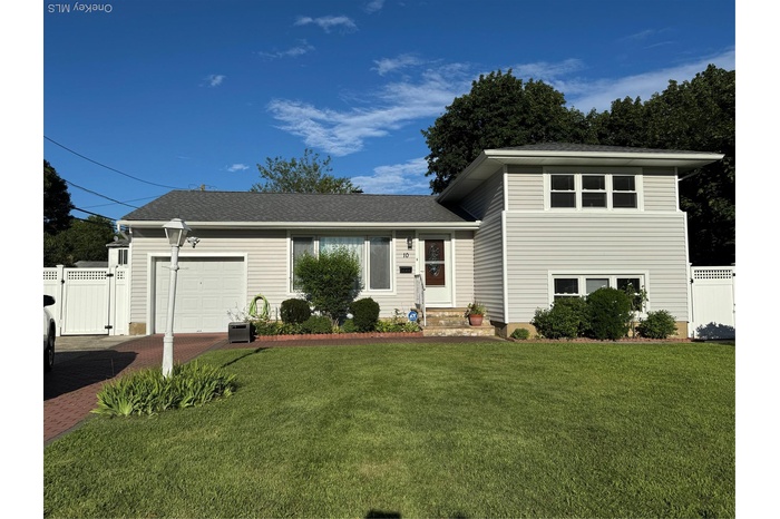 Split level home with a garage, asphalt driveway, a gate, and roof with shingles