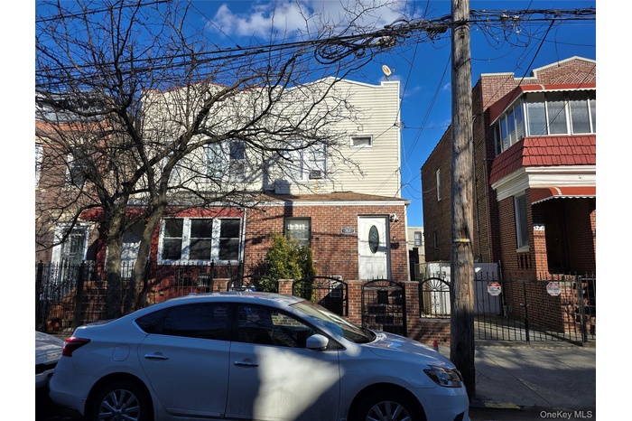 Multi unit property featuring a gate, brick siding, and a fenced front yard